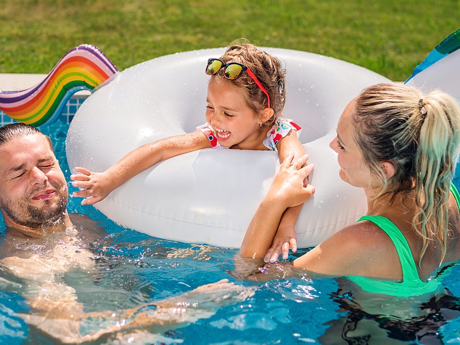 A family playing in a clean backyard pool in Austin